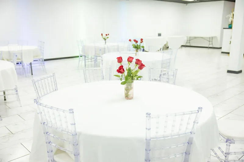 White round table with red roses and clear chiavari chairs at MP Venue Event Center