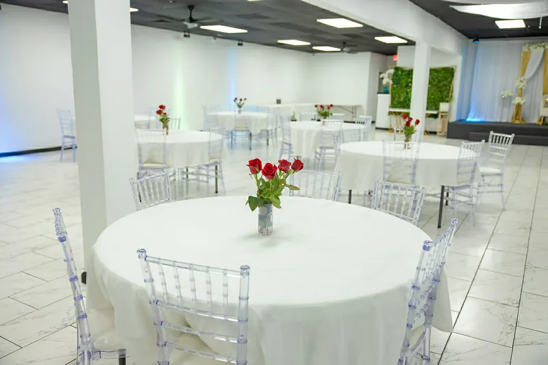 Round tables with red rose centerpieces and ambient lighting at MP Venue